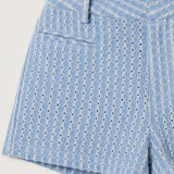 Blue patterned shorts worn by a person on a plain background
