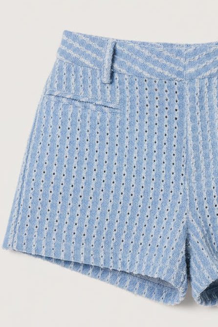 Blue patterned shorts worn by a person on a plain background