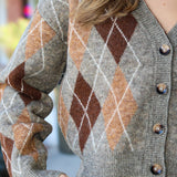 Close-up of a person wearing a argyle patterned cardigan with blurred background