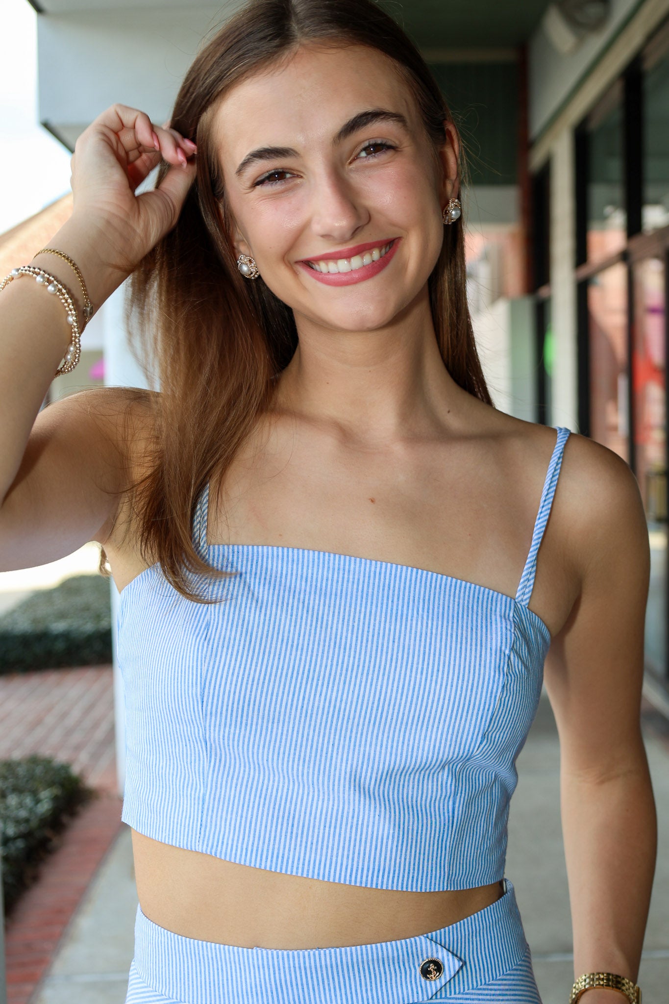 Woman wearing a light blue top with thin straps outdoors