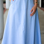 Light blue stripe midi skirt worn by a person with a blurred background