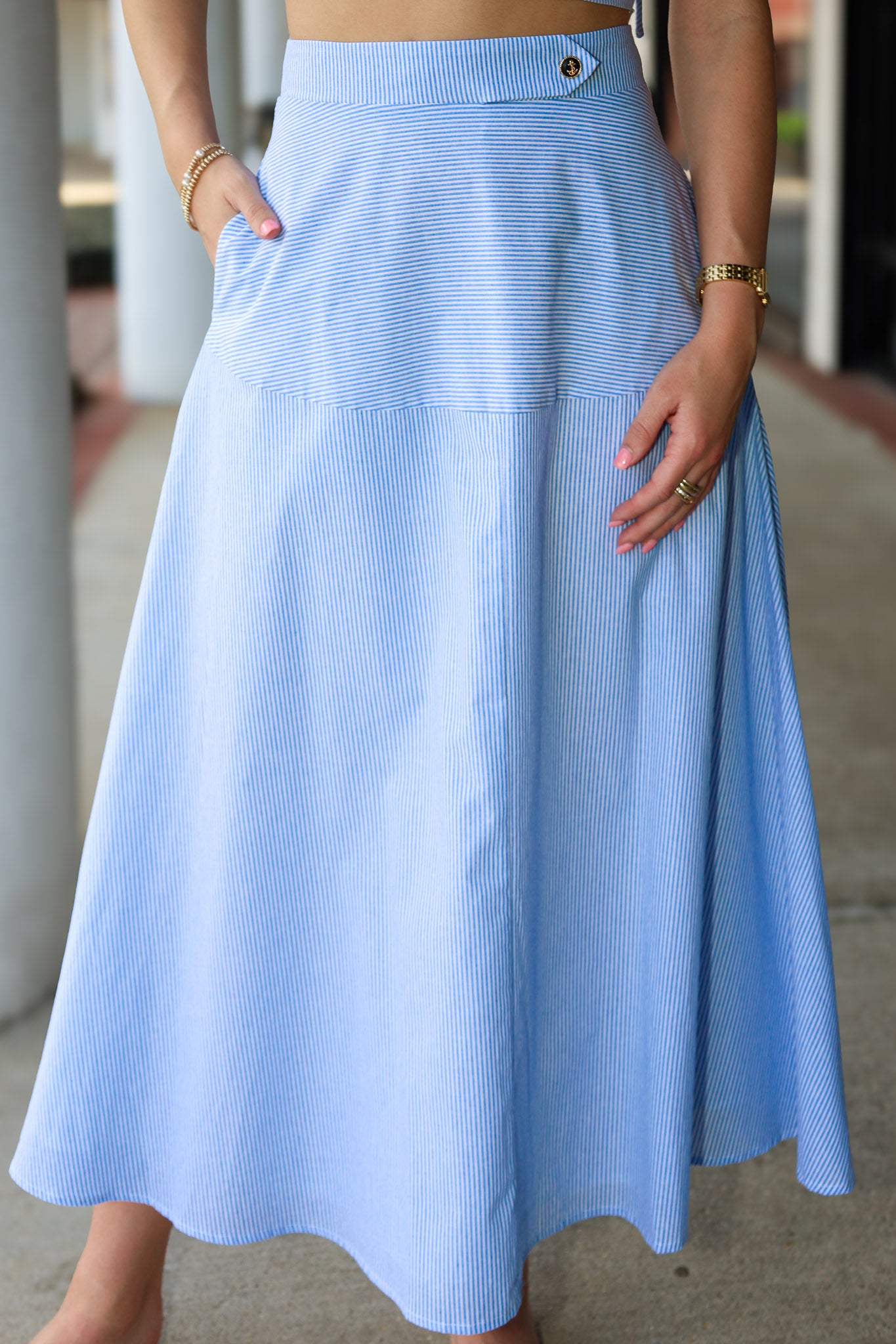 Light blue stripe midi skirt worn by a person with a blurred background