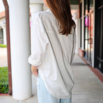 Bea Shirt, NIA - white button down shirt and light blue PISTOLA jeans standing on a sidewalk.