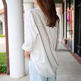 Bea Shirt, NIA - white button down shirt and light blue PISTOLA jeans standing on a sidewalk.