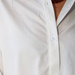 Bea Shirt, NIA - white button down shirt and light blue PISTOLA jeans standing on a sidewalk.