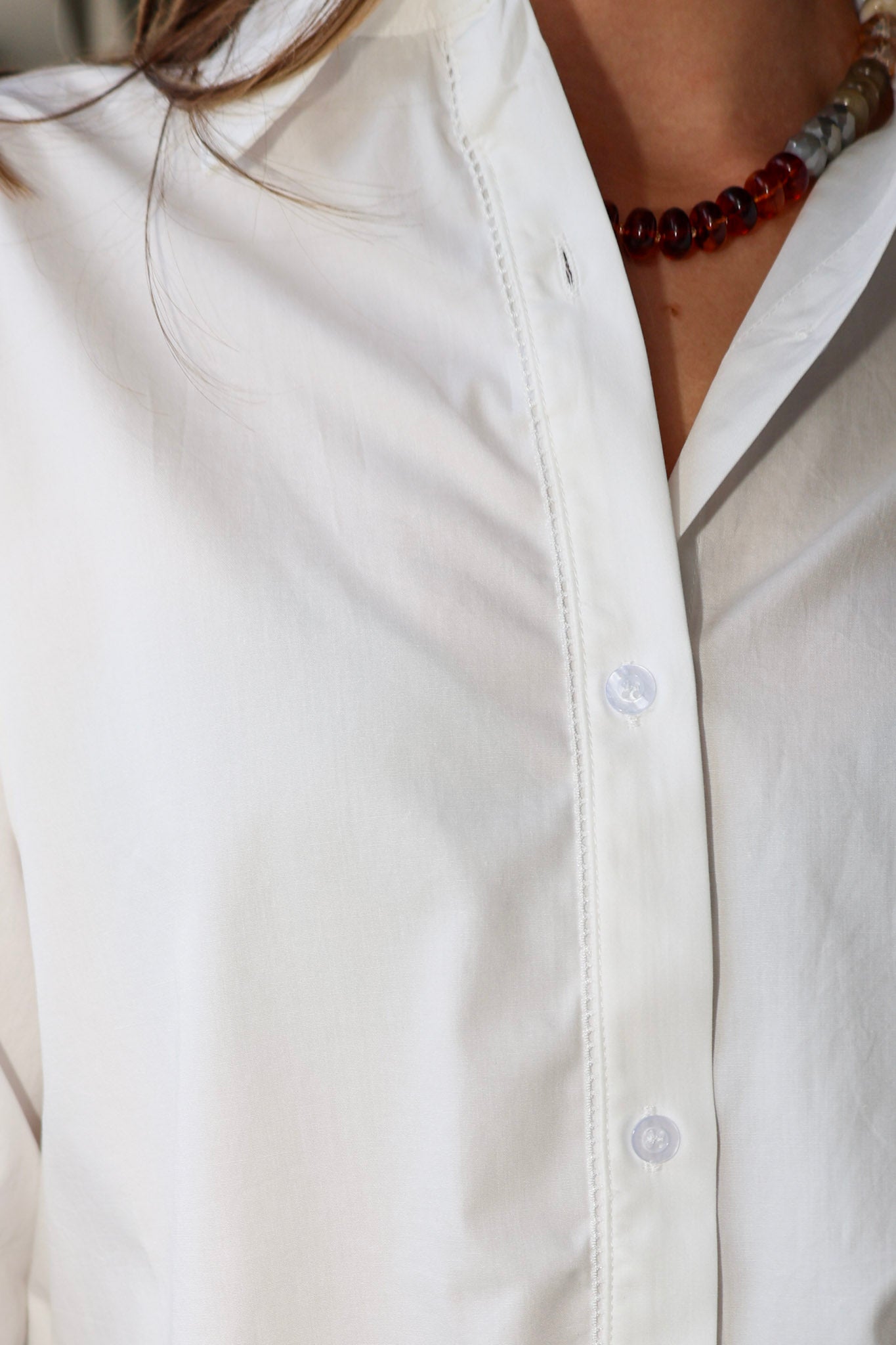 Bea Shirt, NIA - white button down shirt and light blue PISTOLA jeans standing on a sidewalk.