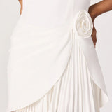 White dress with a pleated skirt and floral detail on a white background