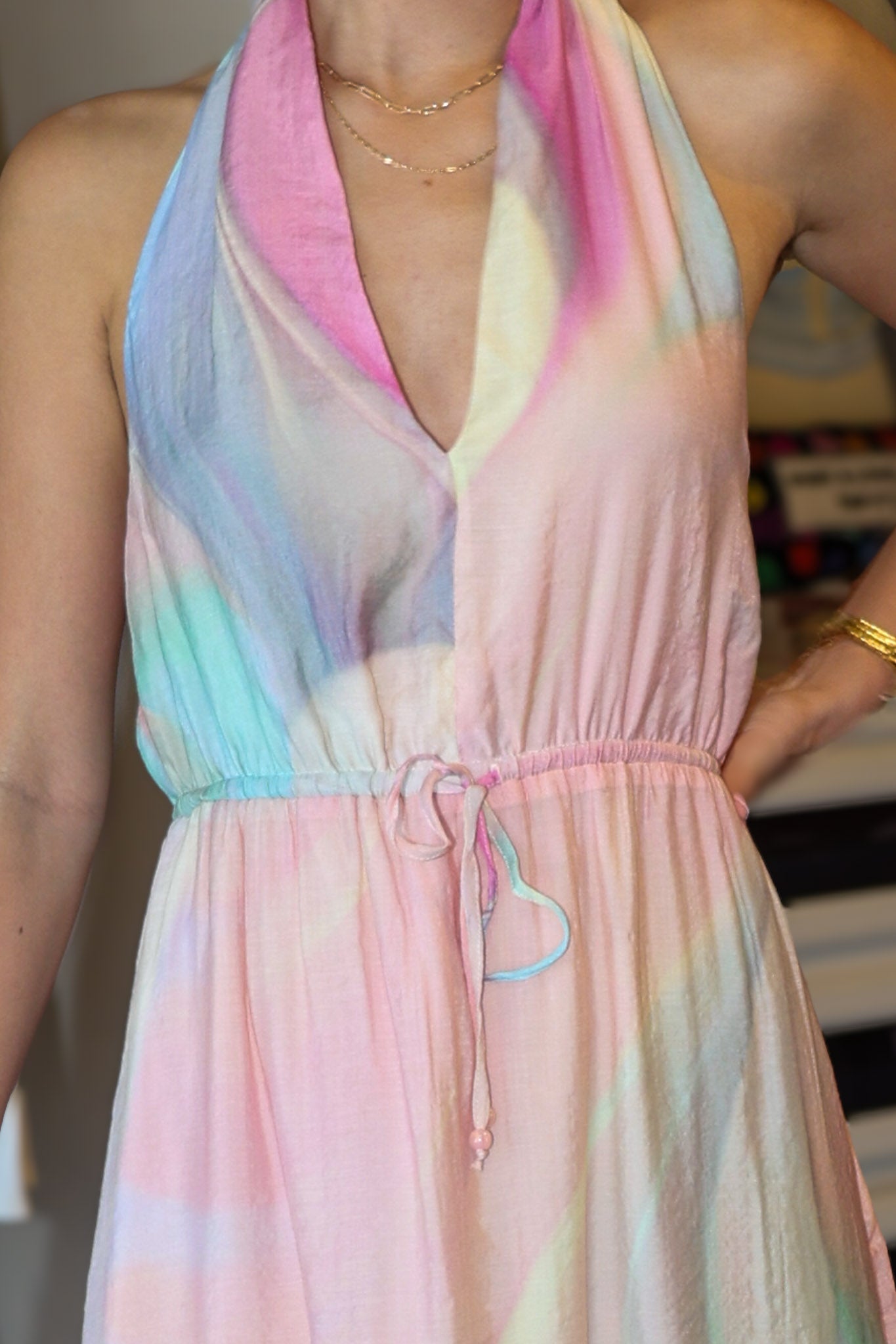 Pastel tie-dye dress worn by a person with a blurred background