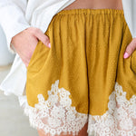 Steve Madden Daisee mustard yellow shorts with lace trim worn by a person.