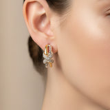 A pair of gold and silver gold butterfly hoop earrings with clear crystals, displayed on a pink 'Rodéo Boutique' card.