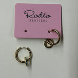Gold hoop earrings on a pink 'Rodeo Boutique' card against a white background