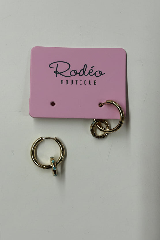 Gold hoop earrings on a pink 'Rodeo Boutique' card against a white background