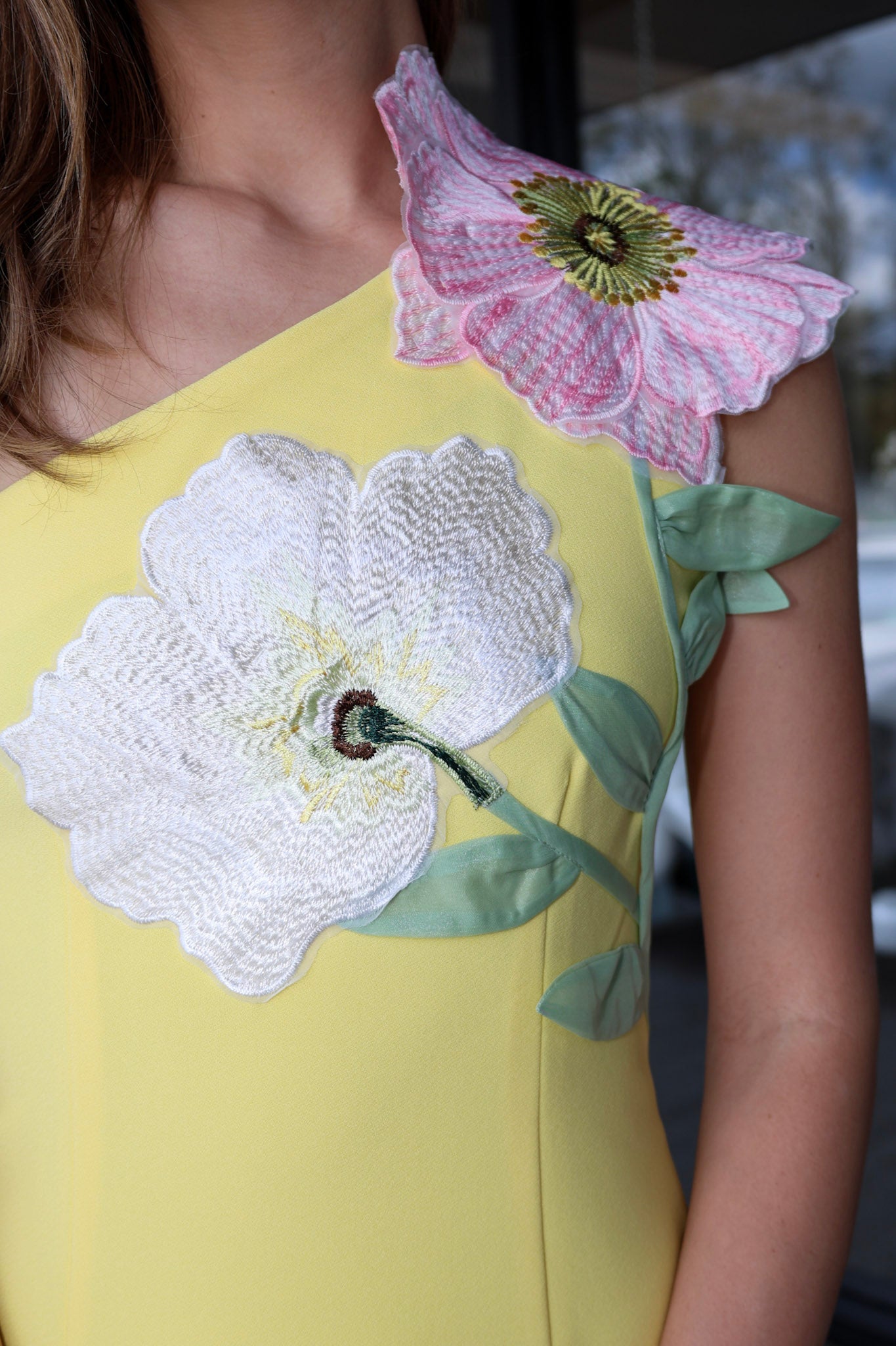 Yellow dress with floral embroidery on a blurred background