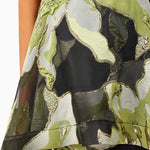 Woman wearing the Elysia dress by Elliatt that is green floral camouflage dress on a white background