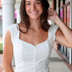 Woman in a white eyelet Emrie Top and matching Emrie skirt.  