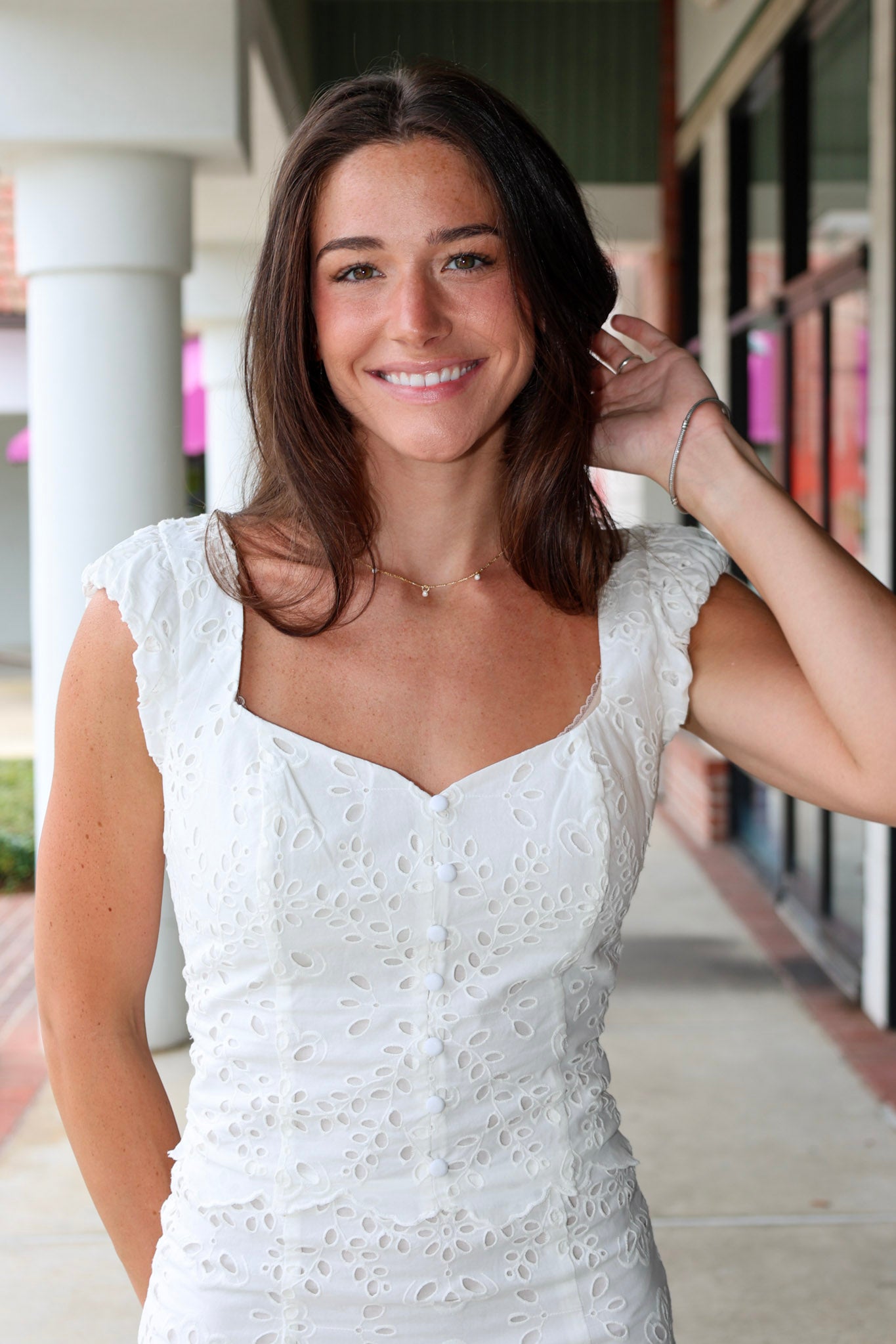 Woman in a white eyelet Emrie Top and matching Emrie skirt.  