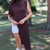 A woman tailgating at LSU  wearing a dark brown high-low cape top, a white mini skirt, and white cowboy boots.