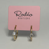 Pink jewelry display card with 'Réléo Boutique' branding holding gold rings.
