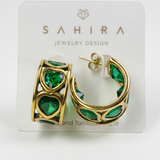 Gold hoop earrings with green heart gemstones on a Sahira Jewelry Design card.