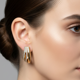 Gold huggie hoop earrings with clear rhinestone accents, displayed on a pink Rodéo Boutique card.