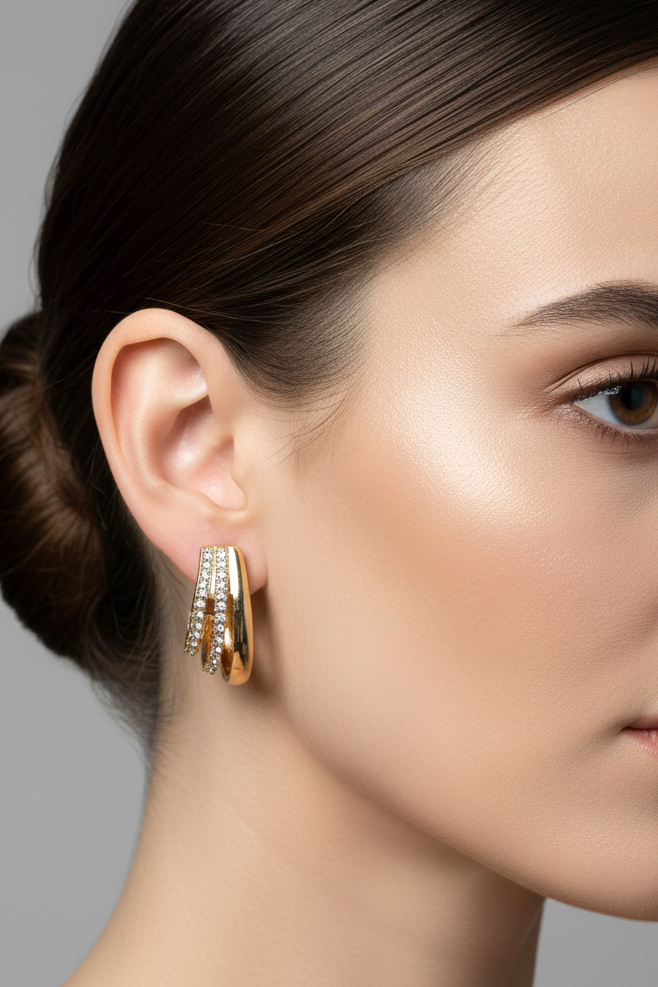Gold huggie hoop earrings with clear rhinestone accents, displayed on a pink Rodéo Boutique card.