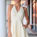 Woman wearing a light-colored dress standing outdoors.