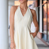 Woman wearing a light-colored dress standing outdoors.