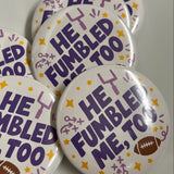 Five round pin-back buttons with a white background, featuring the text 'HE FUMBLED ME, TOO' in purple, decorated with purple and yellow stars and doodles, and one button showing a small brown football.