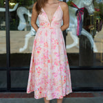 Woman wearing a floral dress standing in front of a carousel.