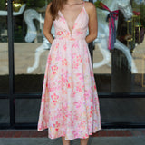 Woman wearing a floral dress standing in front of a carousel.