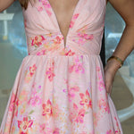 Pink floral dress with a plunging neckline, worn by a person.