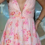 Pink floral dress with a plunging neckline, worn by a person.