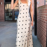 Woman wearing a ivory with black polka dot slip tank dress and black hat going to country concert