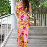 Woman in a floral dress standing on a wooden deck