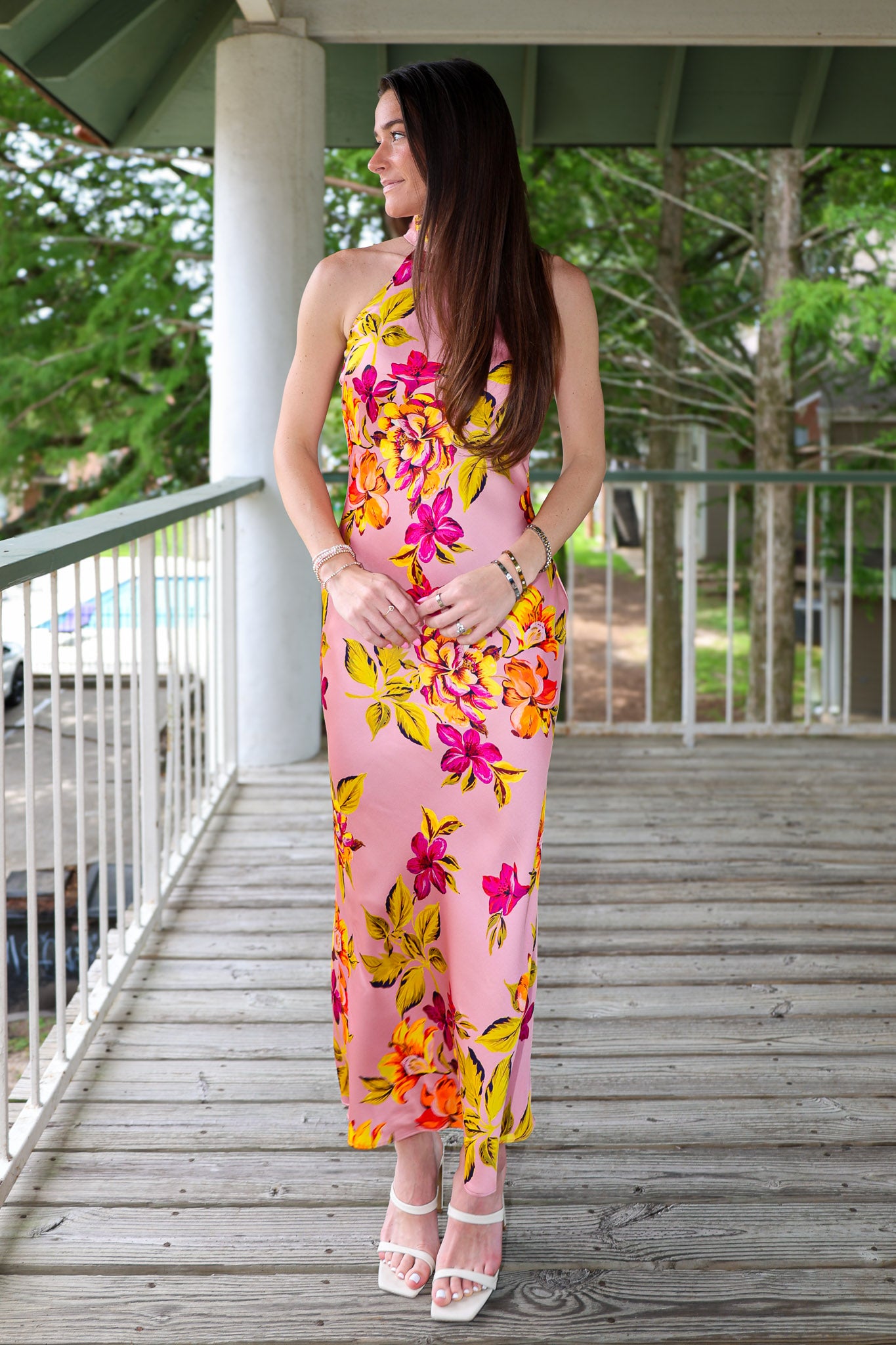 Woman in a floral dress standing on a wooden deck