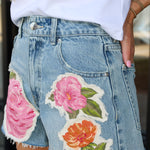 Denim skirt with floral patches worn by a person
