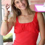 Woman wearing a red top and blue jeans outdoors