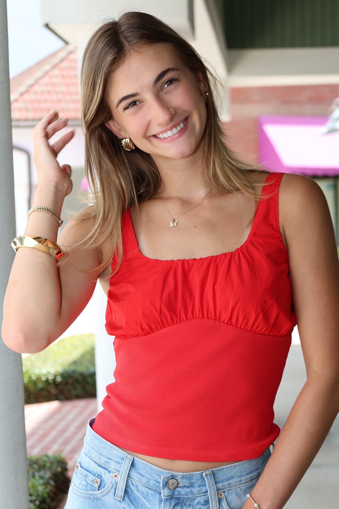 Woman wearing a red top and blue jeans outdoors