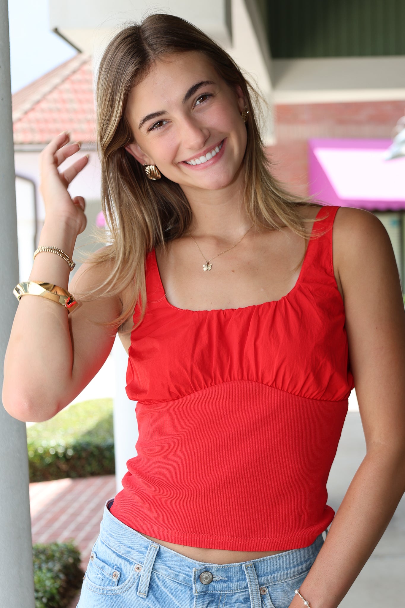 Woman wearing a red top and blue jeans outdoors
