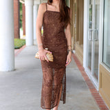 Woman in a brown dress holding a clutch on a sidewalk