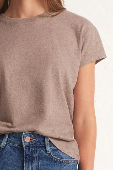 Woman wearing a brown t-shirt and blue jeans on a white background