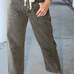 Person wearing polka dot pants with a neutral background