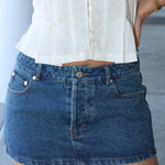 low rise micro mini  blue denim skirt with a blurred background