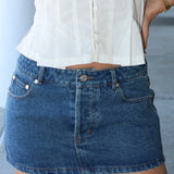 low rise micro mini  blue denim skirt with a blurred background