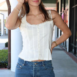 Woman wearing a white top and blue denim mini skirt on a sidewalk.