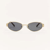 Z Supply Oval sunglasses with a gold-tone metal frame and dark gray lenses, shown from the front on a plain off-white background.
