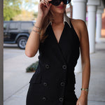 Woman wearing a black blazer dress with sunglasses outdoors.