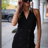 Woman wearing a black blazer dress with sunglasses outdoors.