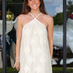 Woman wearing a ivory lace dress standing outdoors with a blurred background