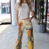 Woman wearing floral-patterned pants standing on a sidewalk.